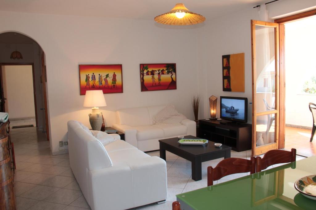 a living room with a white couch and a table at Uliveto in Gioiosa Marea