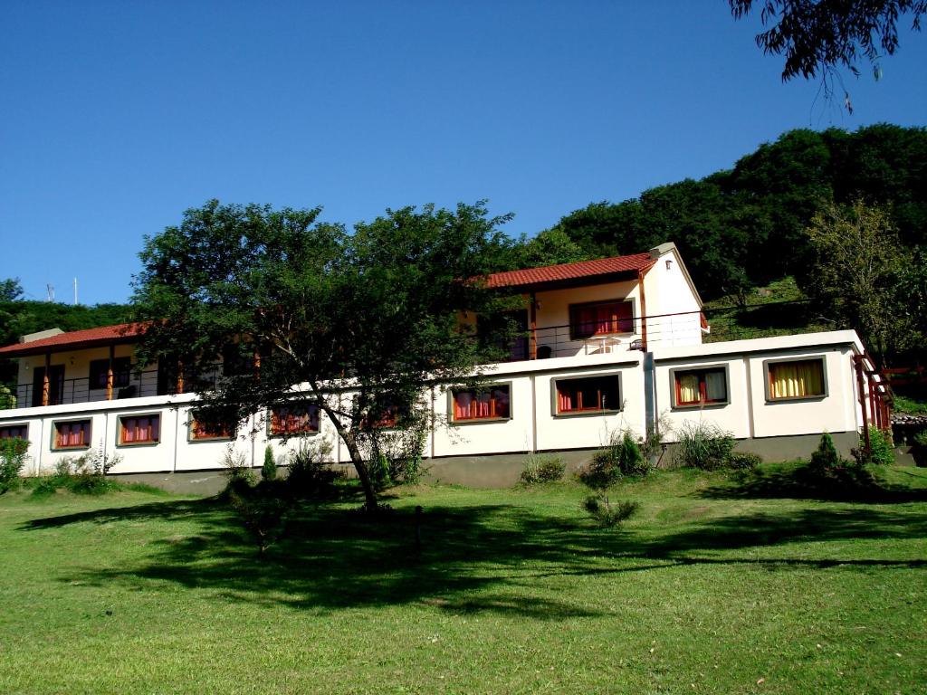 Reyes的住宿－Pura Vida Hosteria，前面有棵树的白色建筑