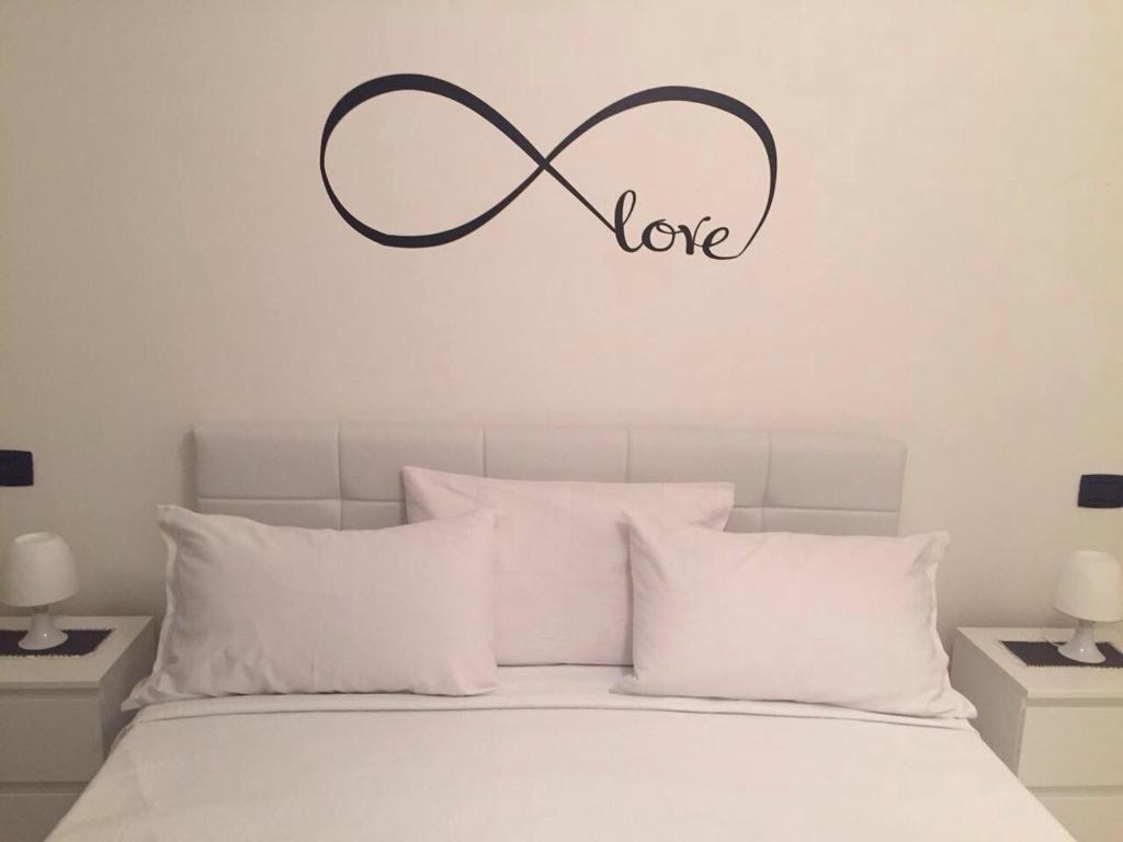 a bedroom with a bed with a sign that says love at Casa Marietta in Polignano a Mare