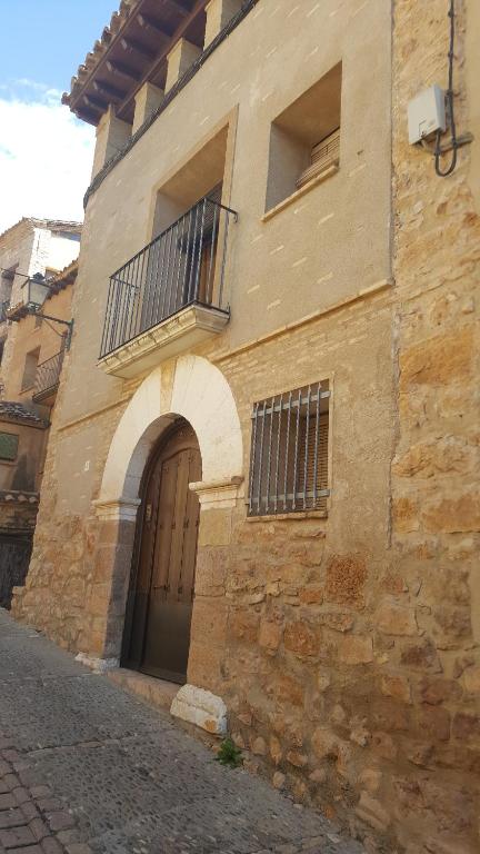 Edificio de piedra con puerta y balcón en Casa Sampietro, en Alquézar