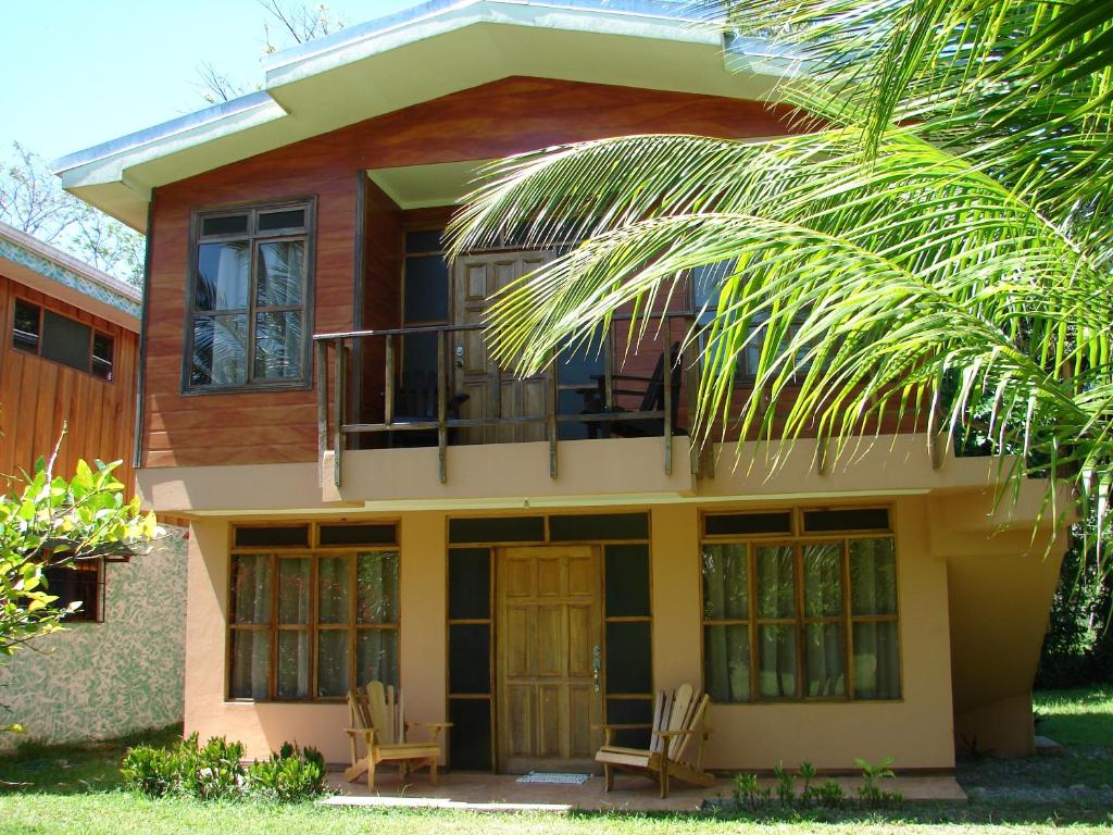 ein Haus mit einem Balkon und einer Palme in der Unterkunft Babilonia in Cahuita