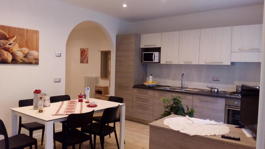 Paganella Apartment في مولفينو: مطبخ وغرفة طعام مع طاولة وكراسي