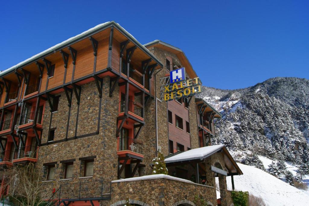 a hotel in the mountains with a sign on it at Xalet Besolí in Arinsal