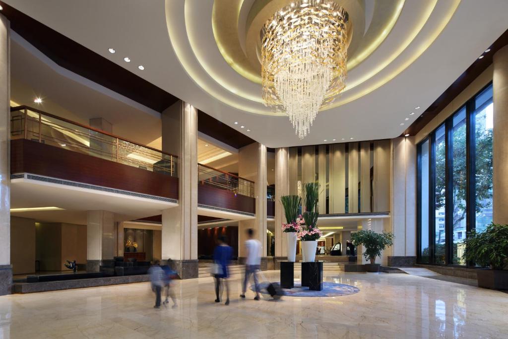 mensen lopen in een lobby met een kroonluchter bij Kunming Haitian Hotel in Kunming