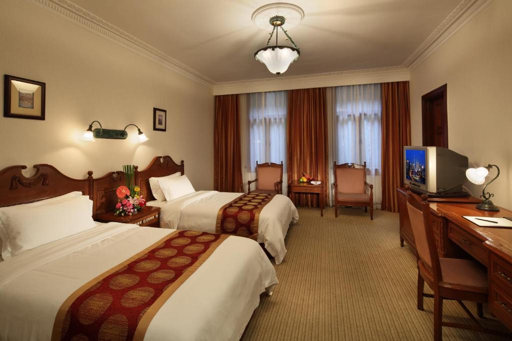 Postel nebo postele na pokoji v ubytování Jin Jiang Pacific Hotel