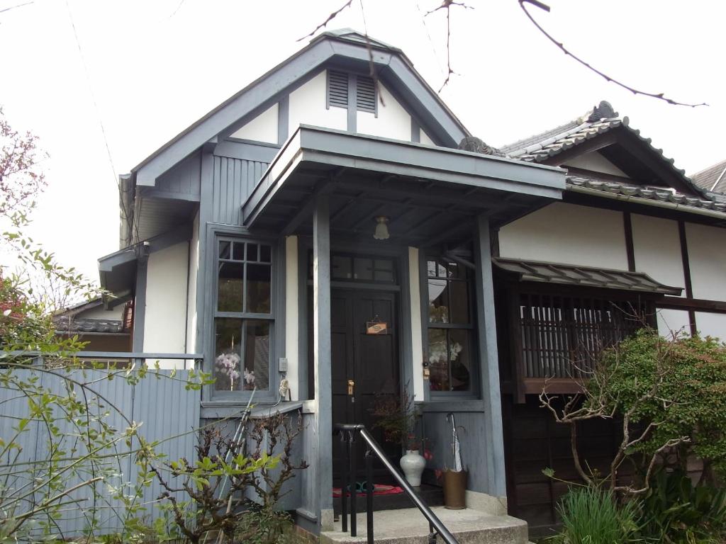 a blue and white house with a porch at Guesthouse Tamura in Nara