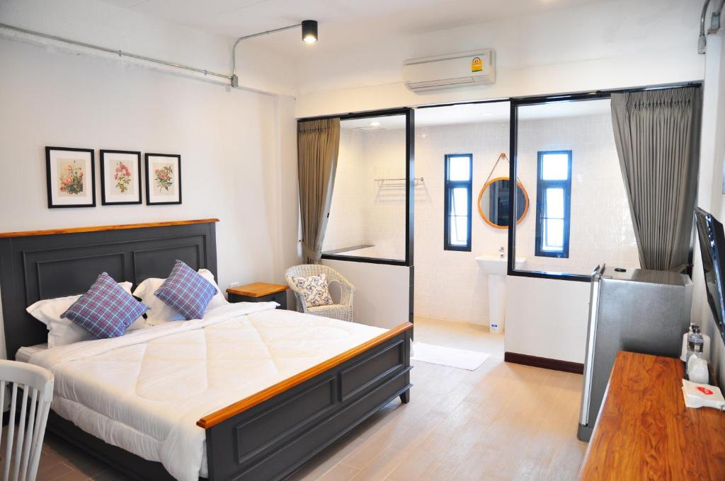 een slaapkamer met een groot bed en een tafel bij C Room "Chomchan" at Airport in Chiang Mai