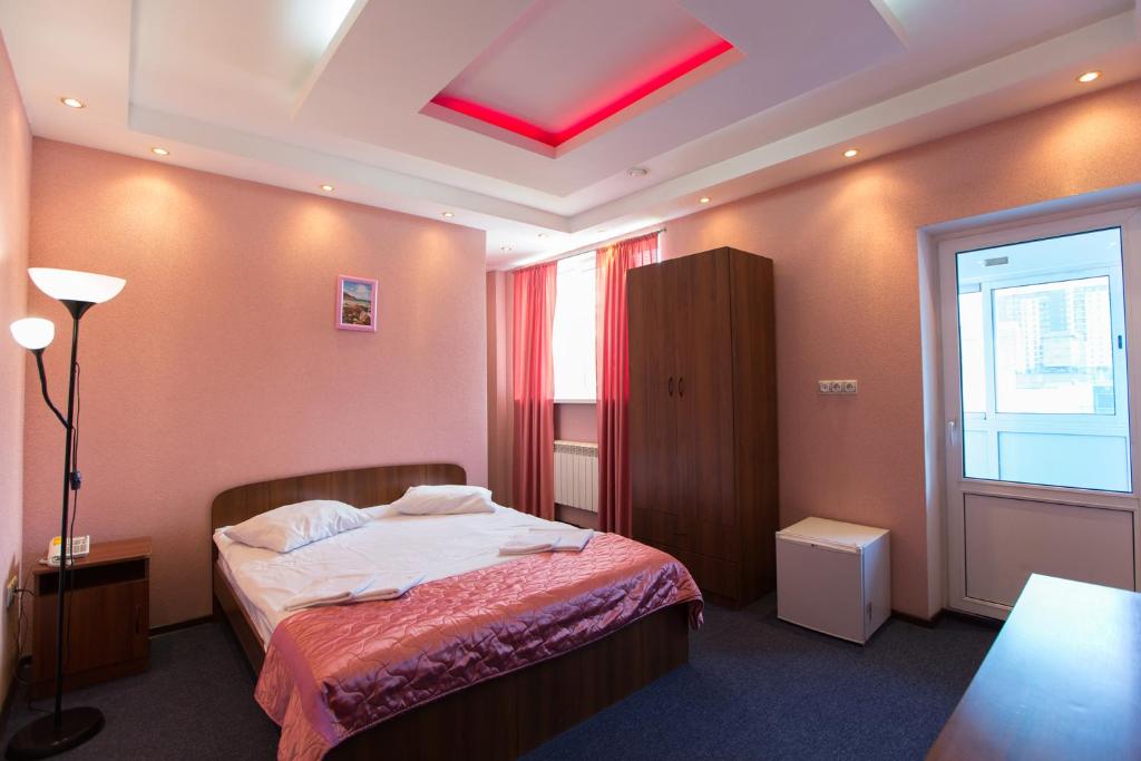 um quarto com uma cama e um tecto vermelho em Antey em Novosibirsk