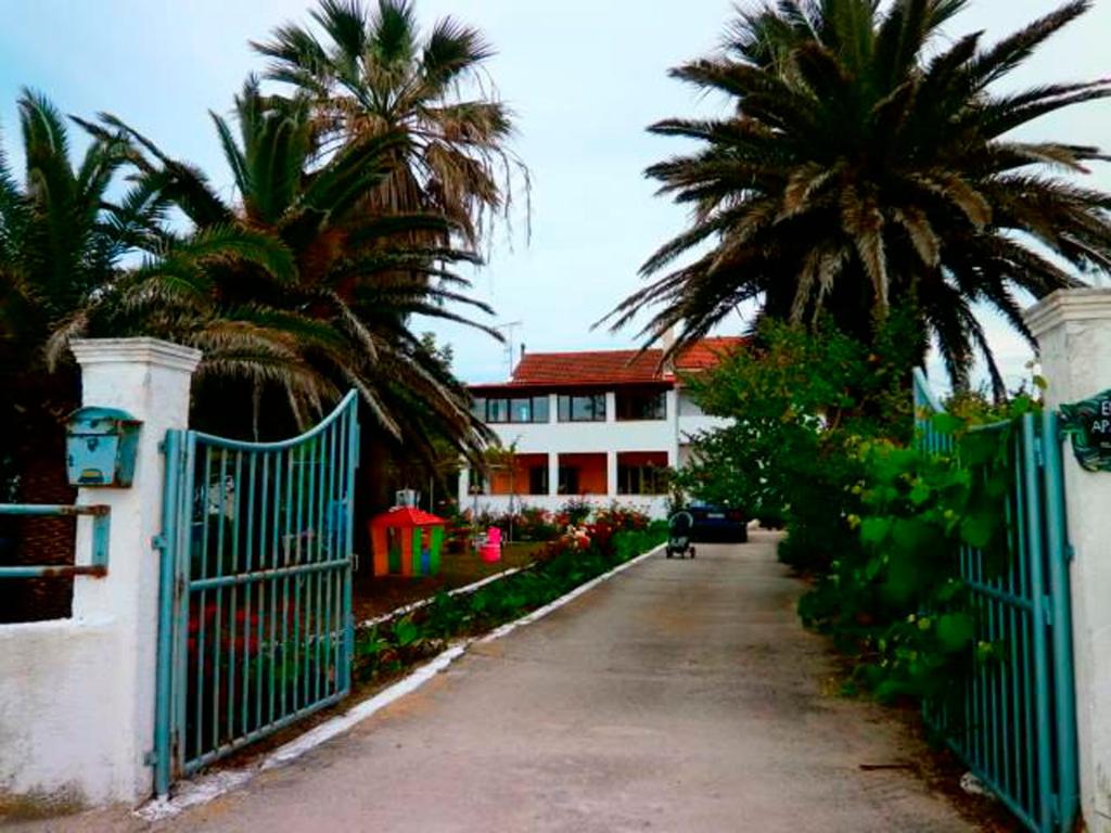 ローダにあるEftichia Apartmentの椰子の木が生える家の前に門を持つ私道