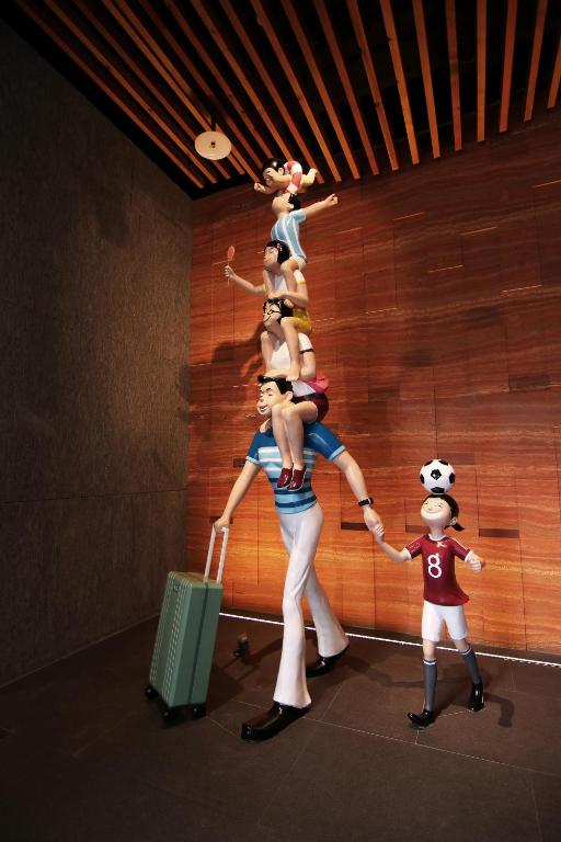 a group of people standing in a room with luggage at H2O HOTEL in Kaohsiung