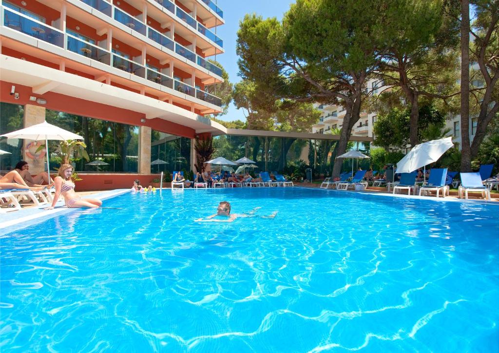 uma família a nadar numa piscina num hotel em Hotel Obelisco em Playa de Palma