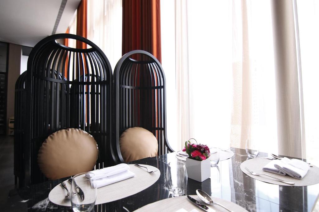 a dining room with two tables and two chairs at H2O HOTEL in Kaohsiung