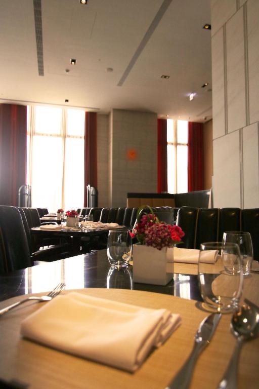a dining room with tables and chairs and a table with napkins at H2O HOTEL in Kaohsiung