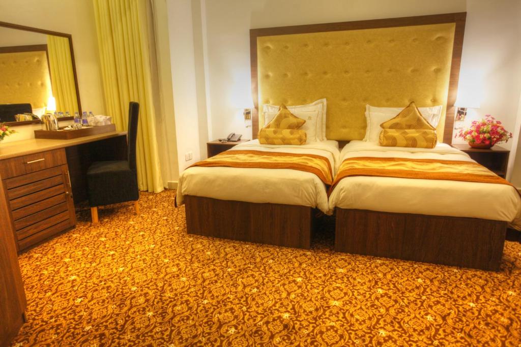 Postel nebo postele na pokoji v ubytování The Queensburry City Hotel