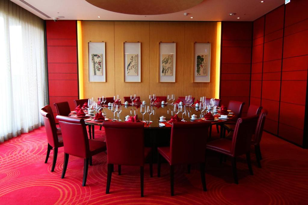 a dining room with a table and red walls at H2O HOTEL in Kaohsiung