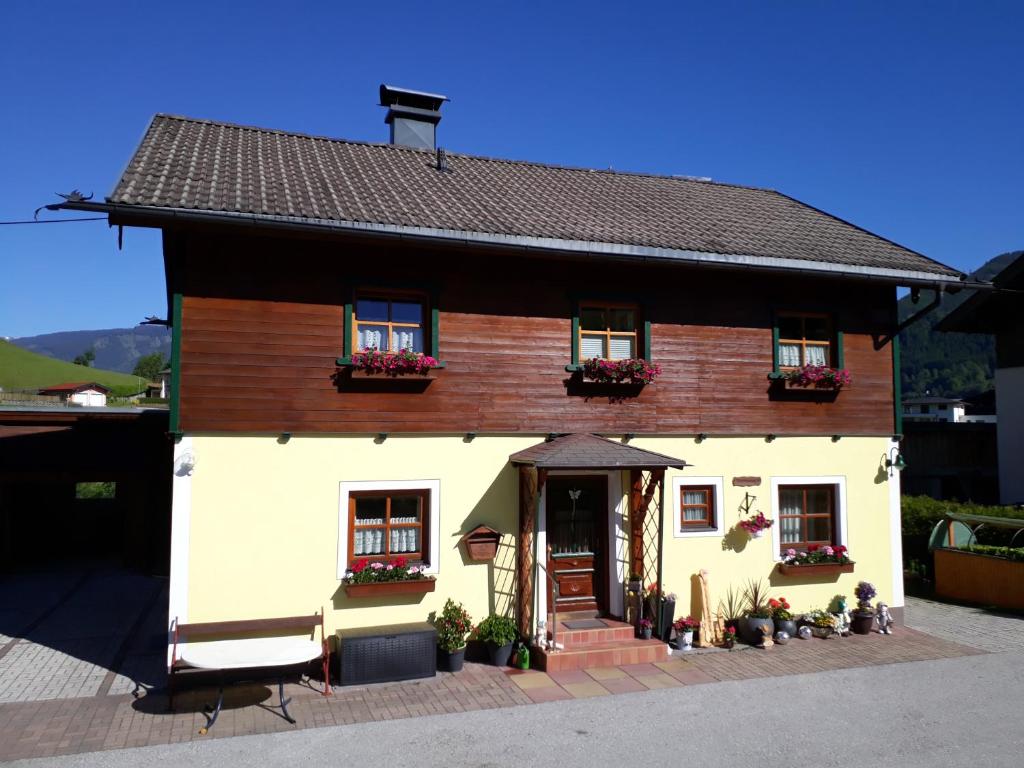 ein kleines weißes Haus mit braunem Dach in der Unterkunft Ferienwohnung Kasbacher in Bruck an der Großglocknerstraße