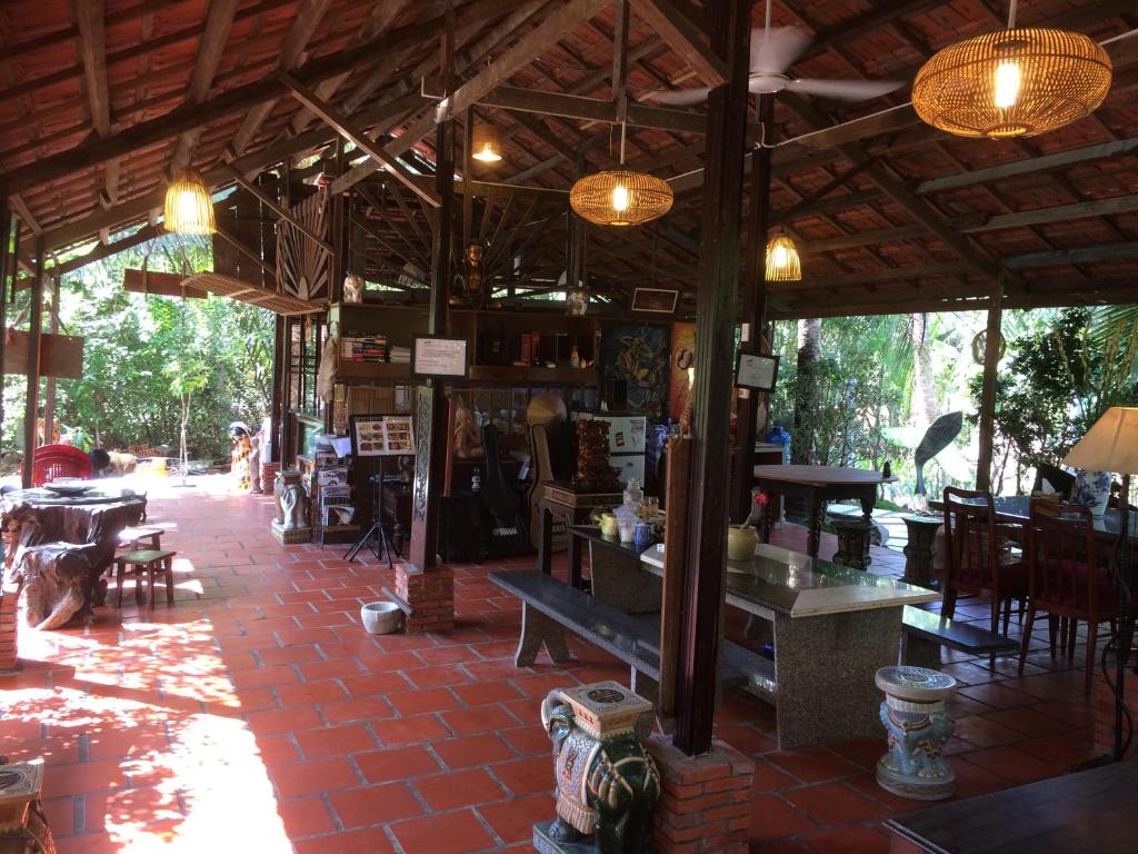 a restaurant with a table and chairs in a building at Charming Countryside Homestay in Ben Tre