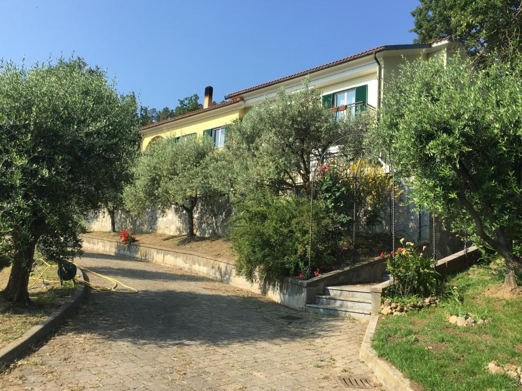 ein Haus mit Bäumen vor einem Hof in der Unterkunft Ospitalità in Campagna in Quiliano