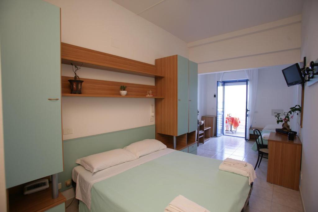 - une chambre avec un grand lit blanc et un bureau dans l'établissement Hotel Atlantic, à Senigallia