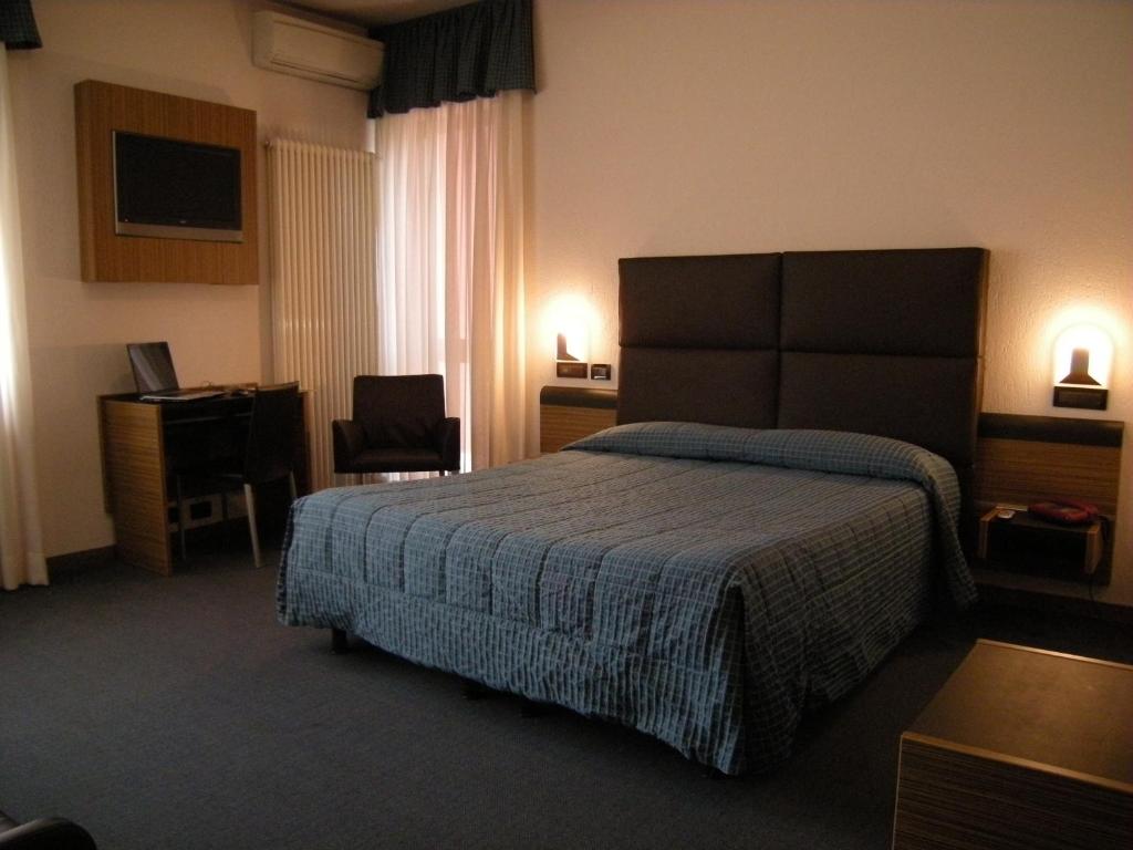 a hotel room with a bed and a desk at Albergo Valle d'Oro in Albino