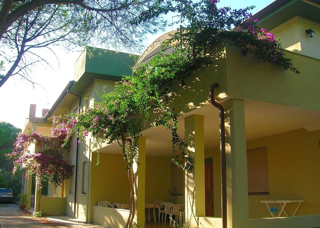 un bâtiment avec des fleurs sur son côté dans l'établissement Sardegna Mare San Giovanni Posada, à Posada