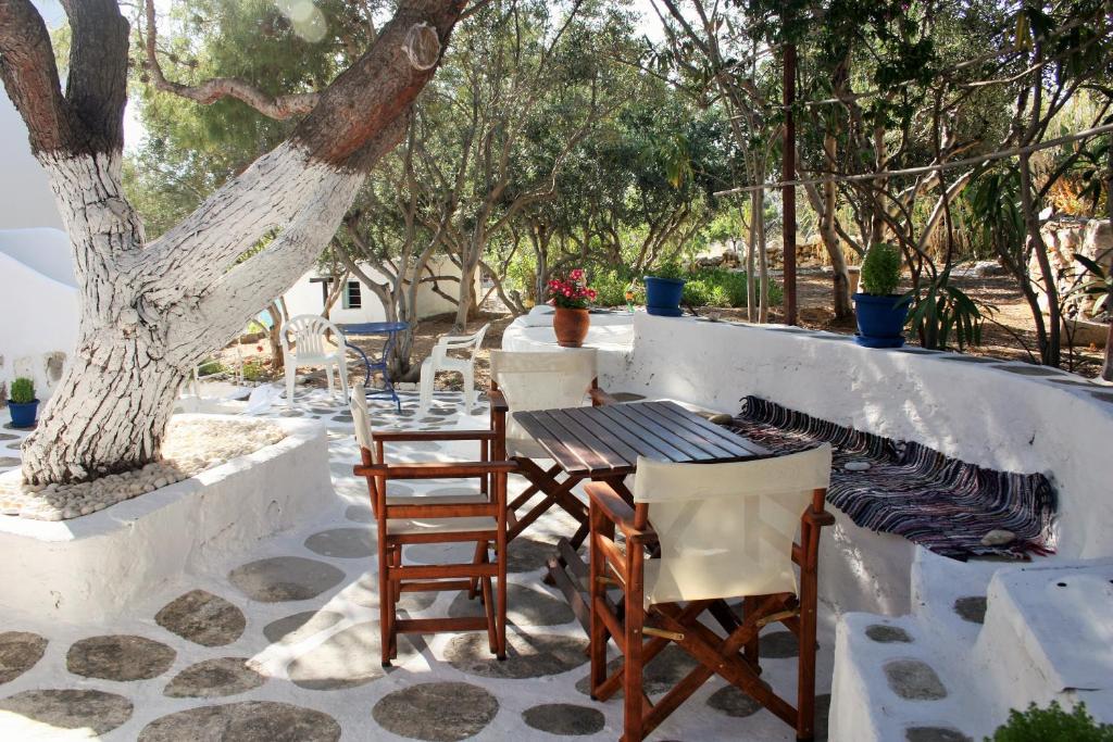 una mesa y sillas en un patio con un árbol en Meltemi Studios and Apartments, en Logaras