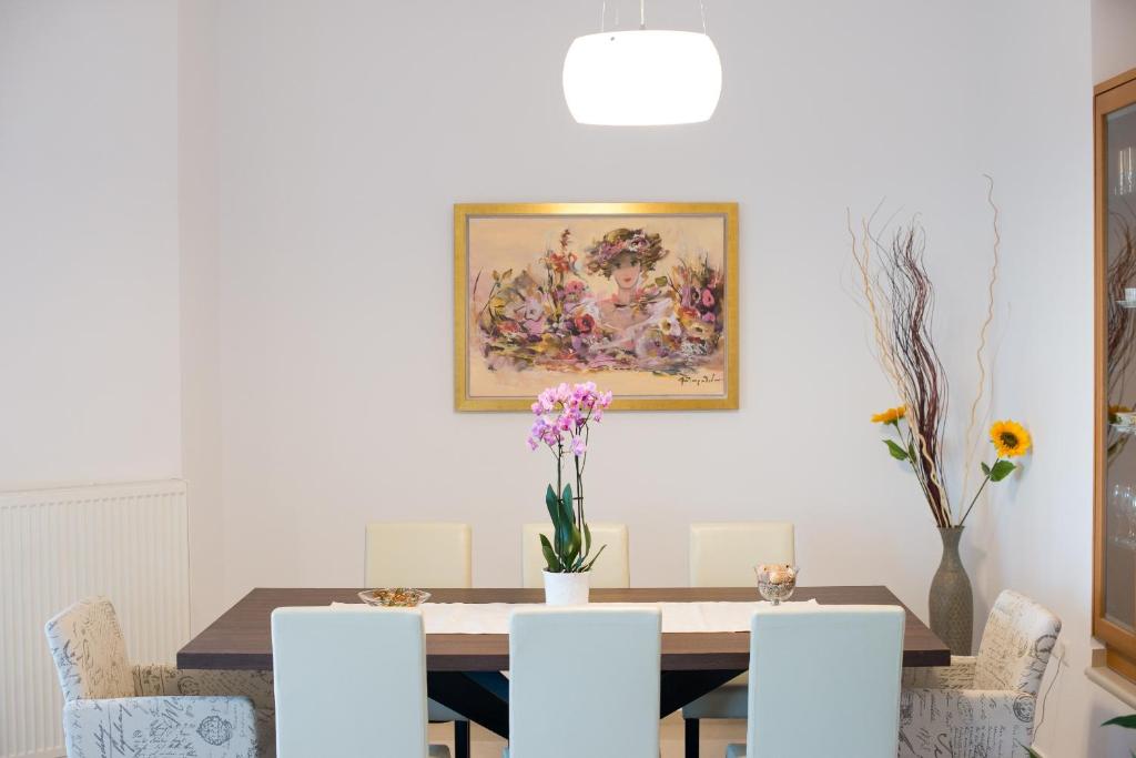 a dining room table with chairs and a painting on the wall at Diogenis Home in Maroulás