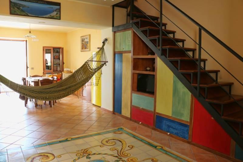 a hammock in a living room with a colorful staircase at La Casa di Ivana in San Nicola Arcella