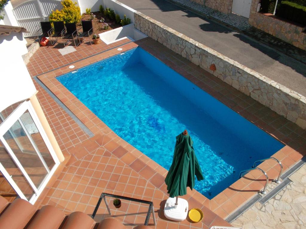 an overhead view of a swimming pool with an umbrella at Can Tapsy in Tossa de Mar