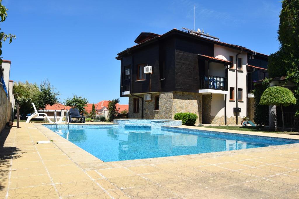 a swimming pool in front of a house at Paradise Bay Villas in Sozopol