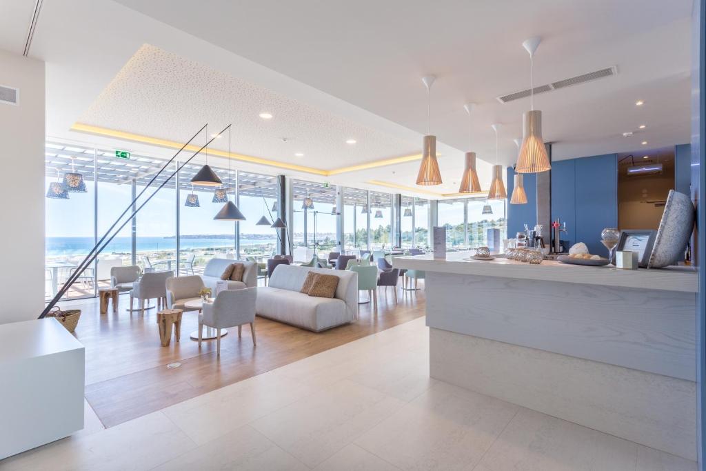 a kitchen and living room with a view of the ocean at Palmares Beach House Hotel - Adults Only in Lagos