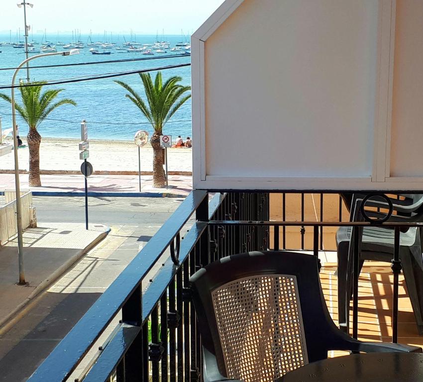 een balkon met een tafel en een stoel en het strand bij Hotel Alaska in Lo Pagán