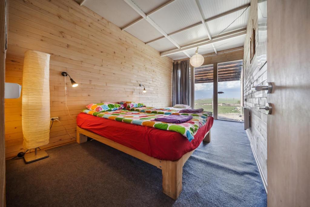 ein Schlafzimmer mit einem Bett in einer Holzwand in der Unterkunft Oasis Club Cottages in Udabno
