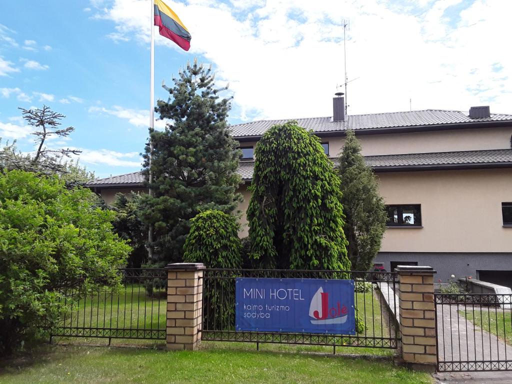 una bandera ondeando sobre una valla delante de un edificio en Jole en Rumšiškės