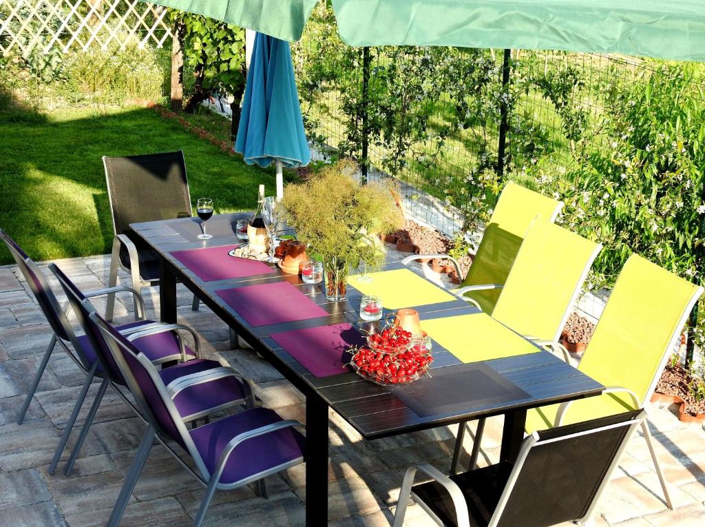 a table with purple and yellow chairs on a patio at Apartmaji Sobe Zvezda in Pobegi