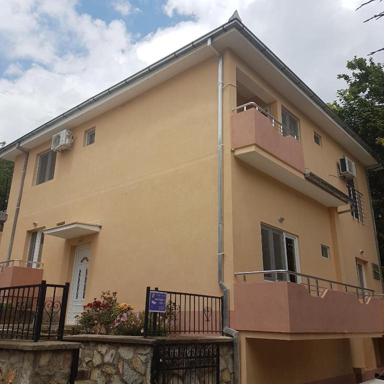 a large yellow house with a balcony at Apartmani Milica Dojran in Star Dojran