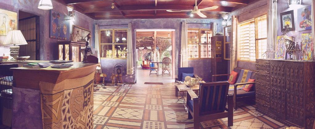 una habitación con bar y un pasillo con una habitación con en Le Karite Bleu en Uagadugú