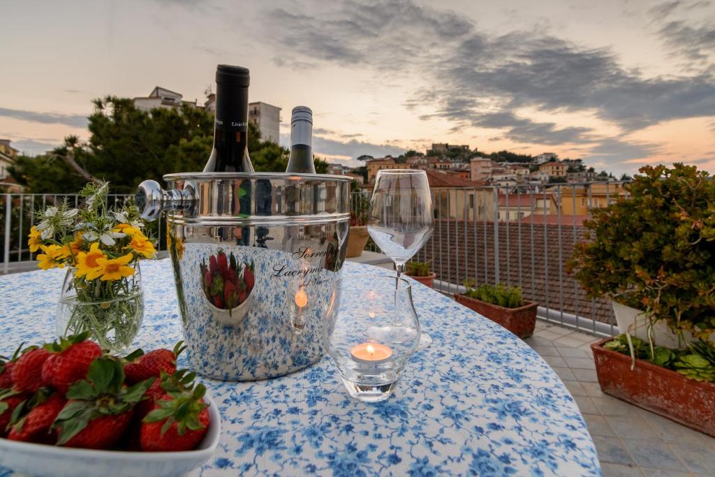 een tafel met wijnglazen en aardbeien op een balkon bij La Tortuga in Agropoli