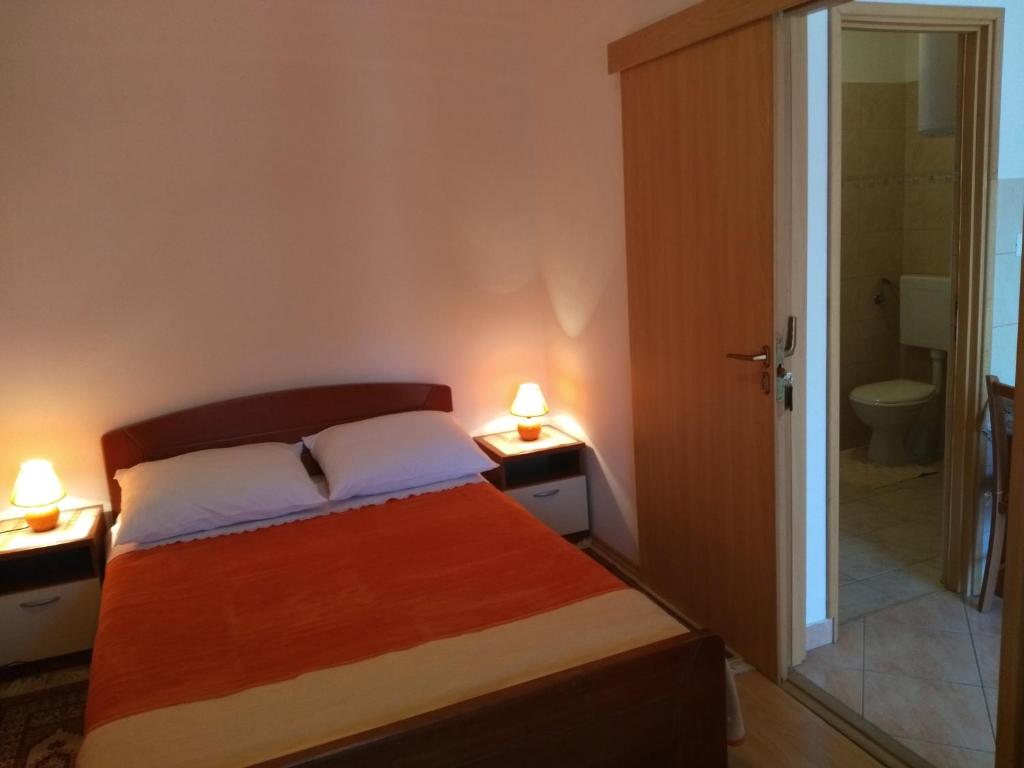 a bedroom with a bed and a bathroom with a shower at Apartment Cvita in Biograd na Moru