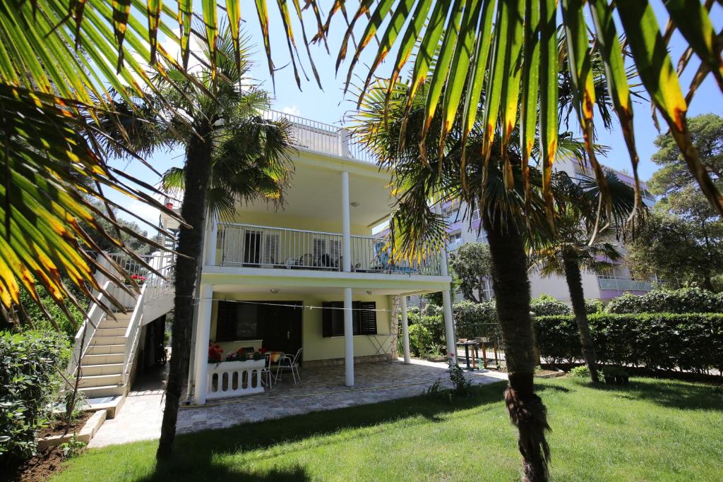 Casa con balcón y palmeras en Apartments Paleka en Petrcane