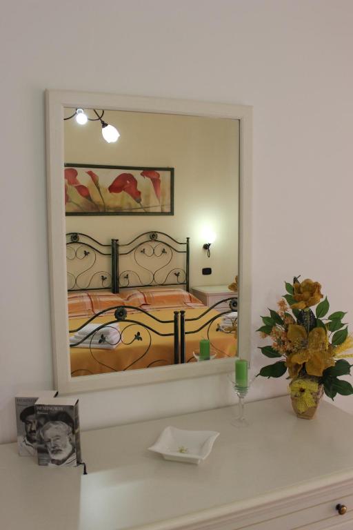 uno specchio che riflette una camera con due letti di B&B LA RONDINE a Santa Domenica Talao