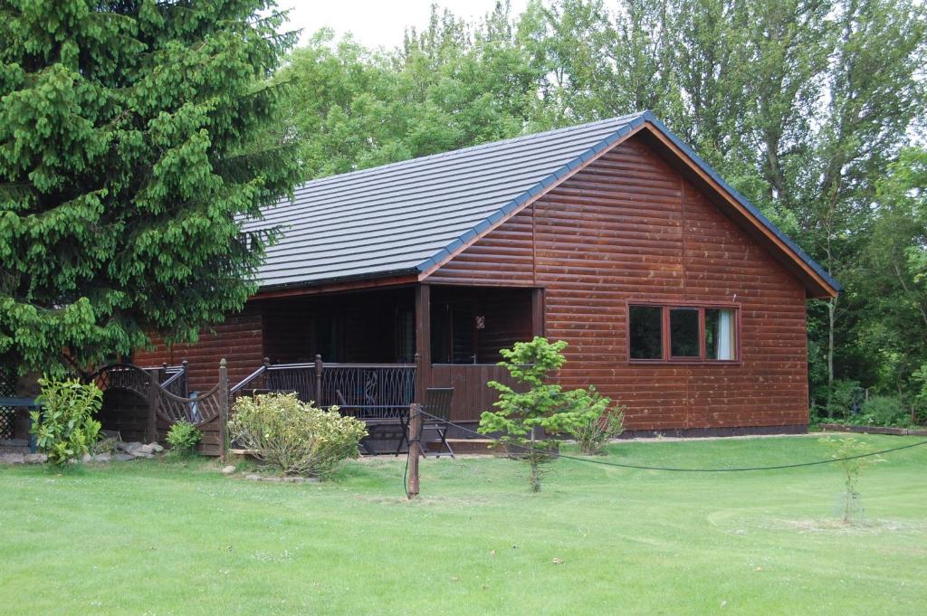 una pequeña casa de ladrillo rojo con patio en Fir Tree Lodge, en Blairgowrie