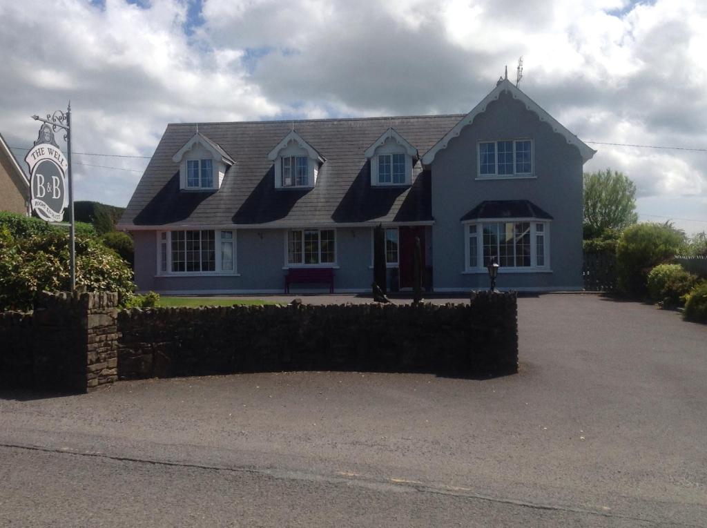 una casa azul con una valla delante de ella en The Well Bed & Breakfast, en Clonakilty