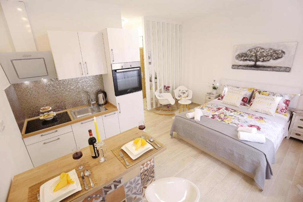 a small bedroom with a bed and a kitchen at A'marie Apartments SELF CHECK-IN in Zadar