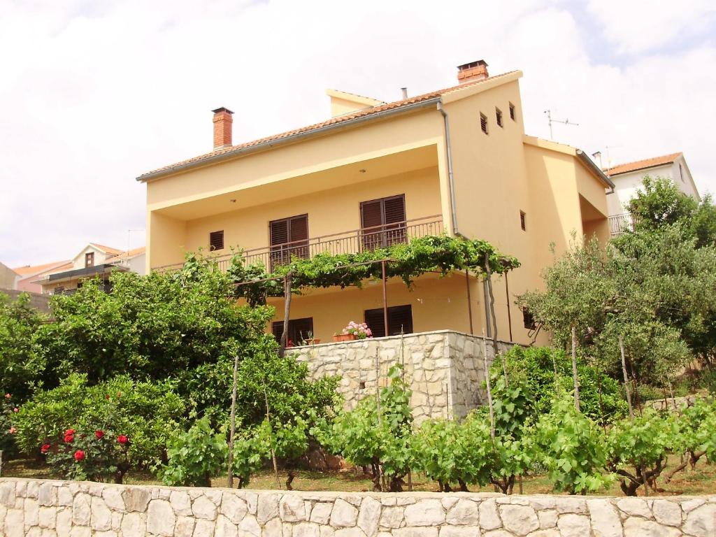 une maison sur une colline avec des arbres devant elle dans l'établissement Apartments Dragan, à Stari Grad