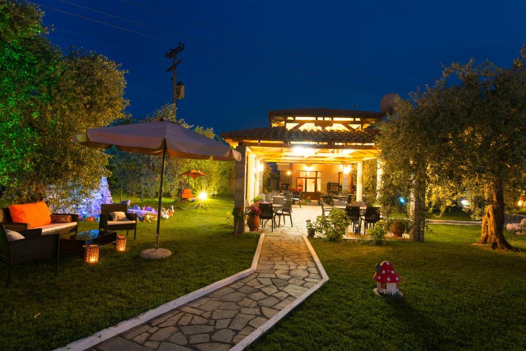 a house with an umbrella in the yard at night at Pension Maria in Astris