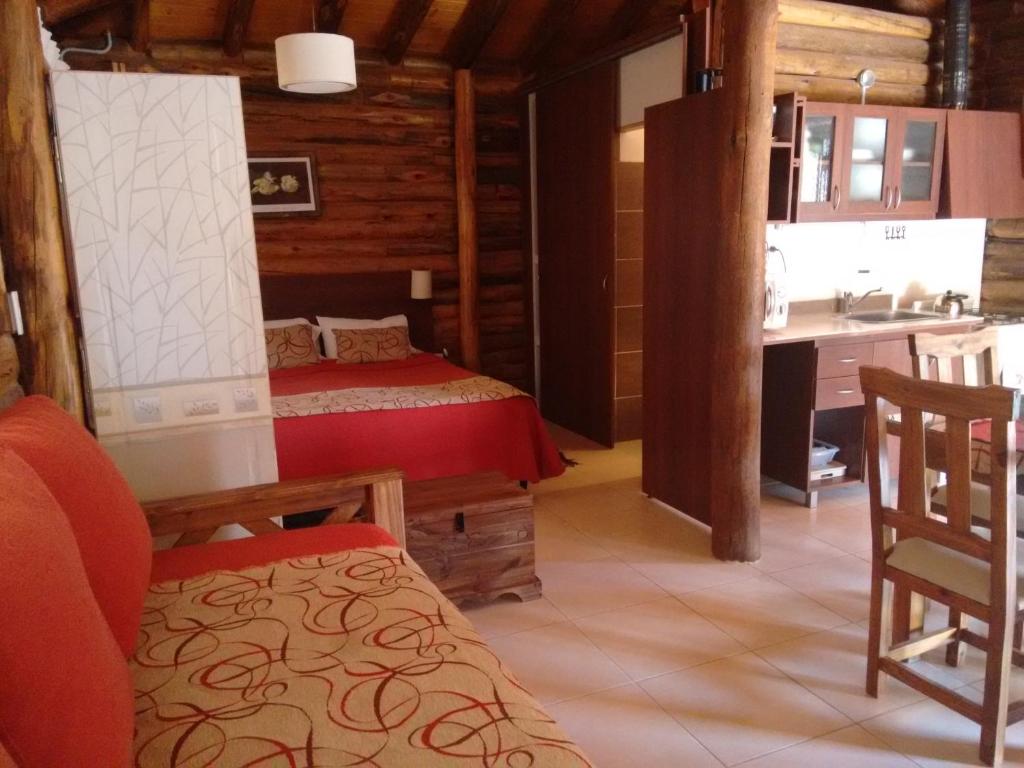 a bedroom with a bed and a kitchen in a house at Mendoza Sol y Nieve in Potrerillos