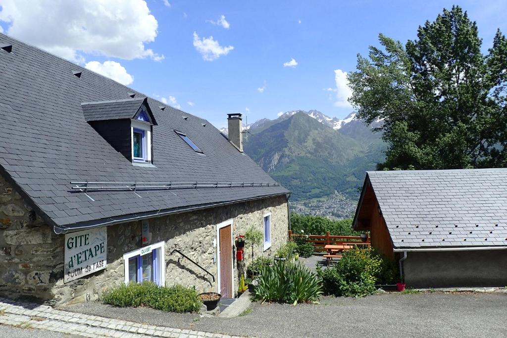 un bâtiment en pierre avec des montagnes en arrière-plan dans l'établissement Gîte Soum de l'Ase, à Grust