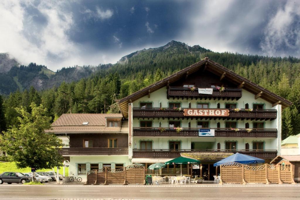 een groot gebouw voor een berg bij T3 Gasthof Spullersee in Wald am Arlberg