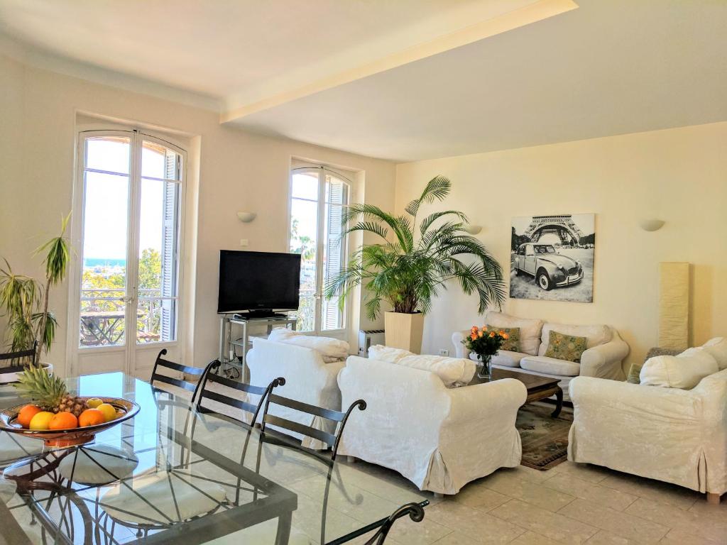een woonkamer met witte meubels en een tafel bij Citilet Louis Blanc 1,2,3 - Three gorgeous, open-plan apartments in Cannes